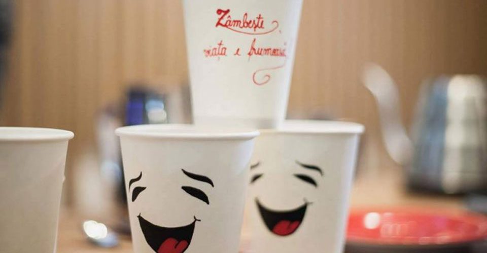 JOY coffee cups reading “Smile, life is beautiful”