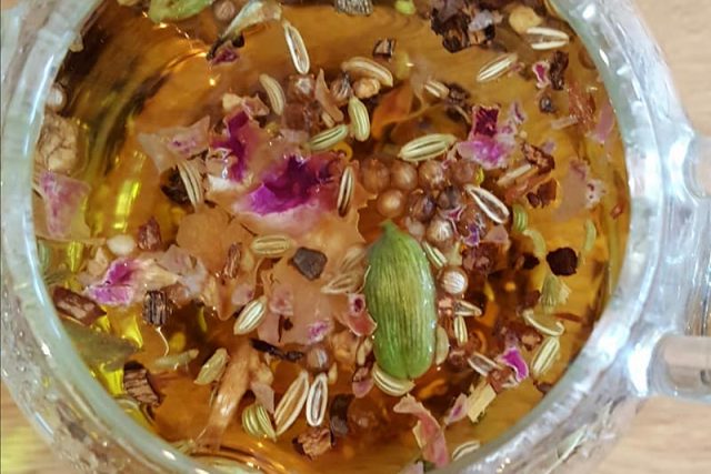 Balance tea in a glass teapot, with rose petals and cardamom