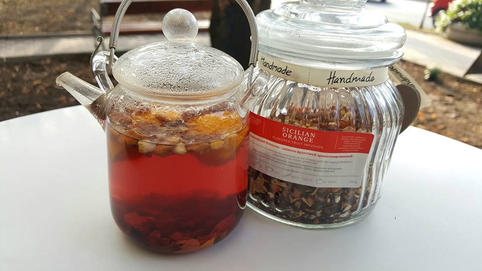 Ceai de fructe în ceainic de sticlă, lângă borcanul cu infuzie