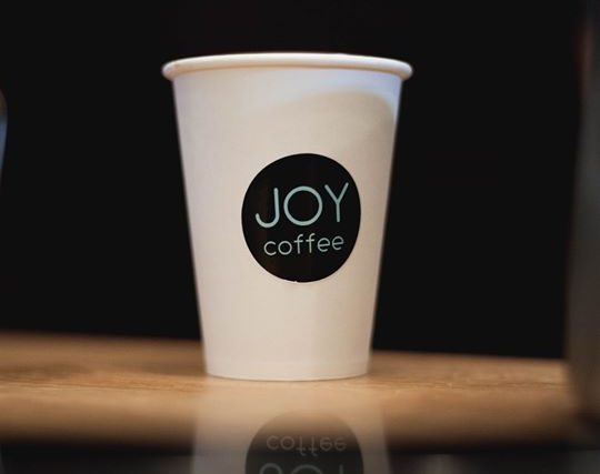 A JOY coffee cup on the counter