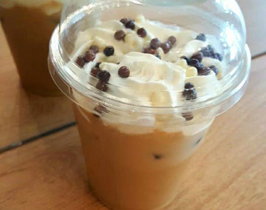 Iced coffee with whipped cream and chocolate pearls