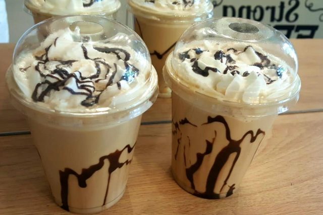Three iced lattes with whipped cream and chocolate sauce